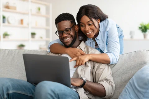 A couple looking at a laptop together.